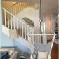 Cozy hanging hammock chair with pillows suspended indoors near staircase in a modern living room